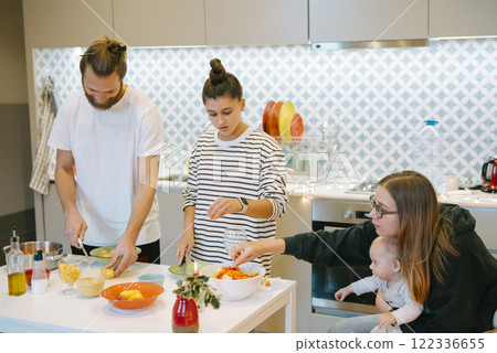 Everyone in the family gathers together to cook a delightful meal in a modern kitchen, 122336655
