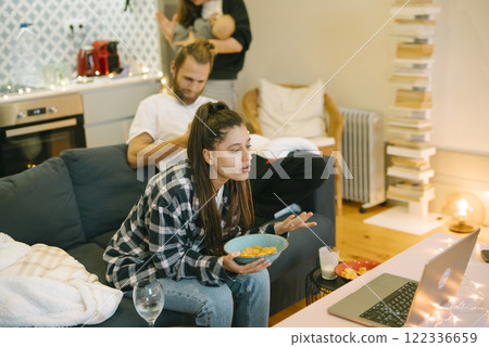 Family Night In Enjoying a Cozy Movie at Home with Snacks for Everyone to Share Family Night In Enjoying a Cozy Movie at Home with Snacks for Everyone to Share 122336659