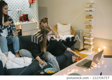 A Casual Gathering of Friends in a Cozy Living Room Surrounded by Delicious Snacks and Drinks A Casual Gathering of Friends in a Cozy Living Room Surrounded by Delicious Snacks and Drinks 122336757