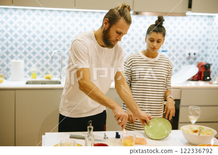 A Happy Couple Enjoying Their Time Cooking Together in a Modern, Stylish Kitchen 122336792