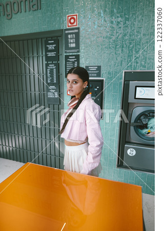 Chic Urban Vibes A Stylish Woman Exudes Elegance in a Modern, Trendy Laundromat Setting 122337060