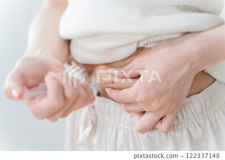A woman who pinches her stomach and injects insulin injection, diet injection, fertility drug 122337148