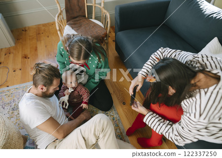 A Family Gathering Featuring a Baby Happily Bonding Together in a Cozy Living Room Setting 122337250