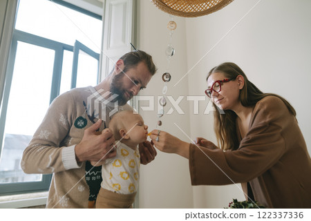 Family Moments Feeding a Baby in a Cozy and Inviting Home Setting for Quality Time Together 122337336