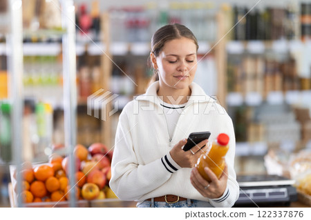 Supermarket visitor buying fruit juice with qr code 122337876