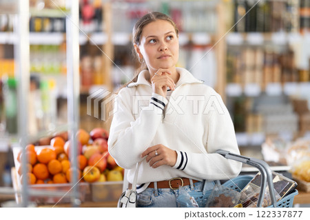 Woman with food basket in store 122337877