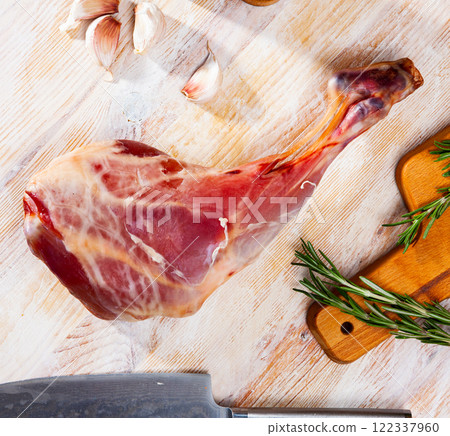 Refined goat leg with rosemary and garlic on cutting board 122337960