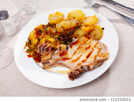 Grilled pork steak with fried potato and braised cabbage Grilled pork steak with fried potato and braised cabbage 122338022