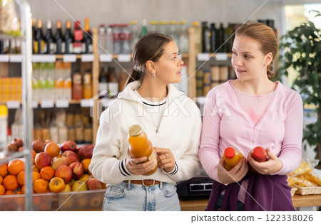 Young women choosing juices in grocery store Young women choosing juices in grocery store 122338026