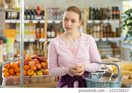 Young girl choosing food in grocery store Young girl choosing food in grocery store 122338027
