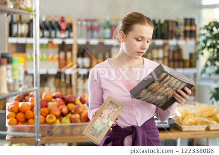 Woman chooses sweet cookies while shopping in grocery supermarket 122338086