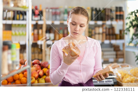 Young girl choosing cheese in grocery store 122338111