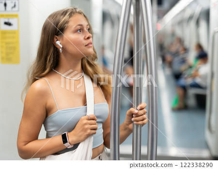 Young girl standing in wagon with wireless headphones on airs Young girl standing in wagon with wireless headphones on airs 122338290