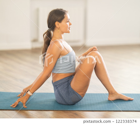 Young woman practicing vinyasa yoga in studio Young woman practicing vinyasa yoga in studio 122338374