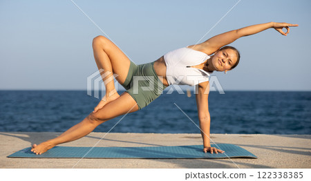 Various yoga poses performed by a sporty girl on sunny seaside Various yoga poses performed by a sporty girl on sunny seaside 122338385