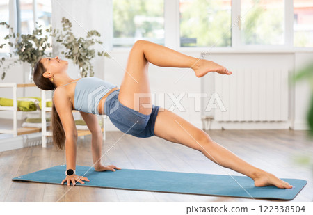 Young fit girl performing Upward Plank Pose during yoga session 122338504