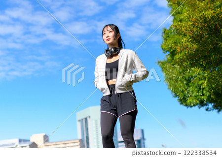 一個酷女人沿著河邊人行道行走，看起來不錯，節食，散步，鍛煉，修剪 122338534