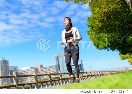 一個酷女人走在河邊的人行道上，散步，節食，散步，運動。 122338535