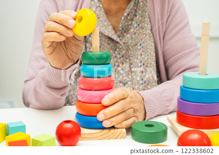 Alzheimer disease AD, Asian elderly woman patient suffering from dementia learn practical motor skills rehabilitation. Alzheimer disease AD, Asian elderly woman patient suffering from dementia learn practical motor skills rehabilitation. 122338602