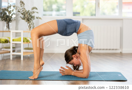Lover of active lifestyle on yoga mat perform doing Ardha chakrasana in gym Lover of active lifestyle on yoga mat perform doing Ardha chakrasana in gym 122338610