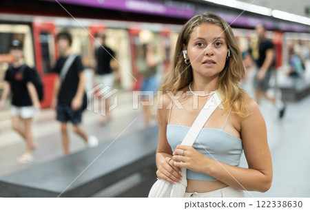 Young girl standing in platform with wireless headphones on airs Young girl standing in platform with wireless headphones on airs 122338630