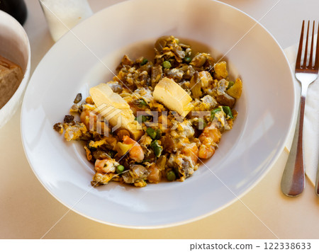 Hearty and healthy meal is fried scrambled eggs with pieces of mushrooms, herbs and shrimp 122338633