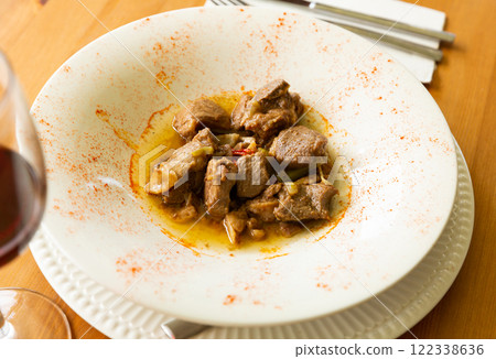 Lamb stew with garlic shoots seasoned with smoked paprika 122338636