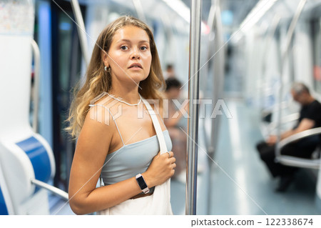 Young girl standing in wagon travelling by subway Young girl standing in wagon travelling by subway 122338674