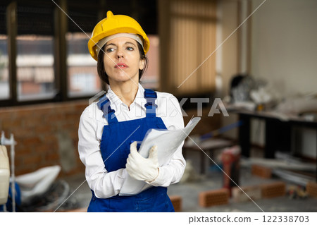 Female worker filling documentation while standing in apartment during repair works 122338703