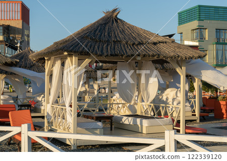 Rows of bungalows on a sandy beach. 122339120