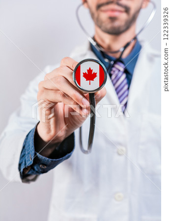 Canada health and medical insurance concept. Canadian Healthcare System, doctor holding stethoscope Canada health and medical insurance concept. Canadian Healthcare System, doctor holding stethoscope 122339326