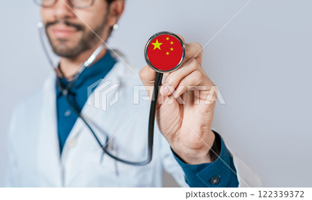 Doctor holding stethoscope with China flag. Chinese Health and Care Concept, China flag on stethoscope Doctor holding stethoscope with China flag. Chinese Health and Care Concept, China flag on stethoscope 122339372