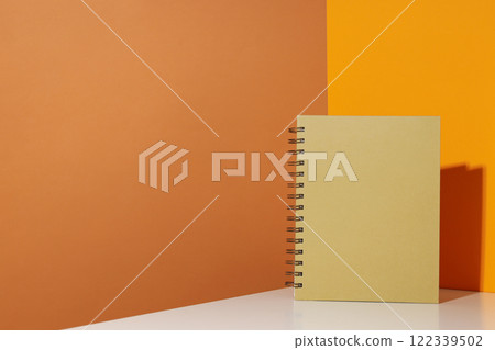 The notebook stands on a yellow background 122339502