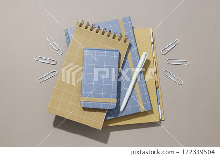 Various notebooks with a pen and paper clips Various notebooks with a pen and paper clips 122339504