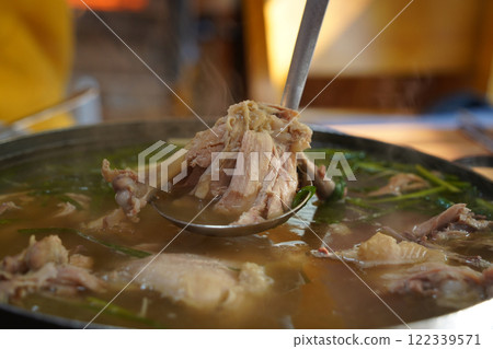 Korean food made by boiling whole chicken with garlic and seasoning it with salt 122339571