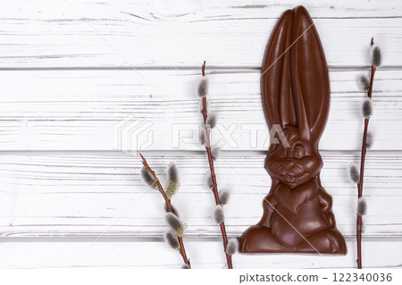 Easter chocolate bunny, willow branches on white table. Easter chocolate bunny, willow branches on white table. 122340036