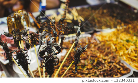 Deep-fried scorpions and other insects are popular exotic street snacks in Thailand, known for their crispy texture and unique flavors. 122340331
