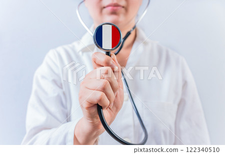 Female doctor holding stethoscope with France flag. National Health System of France 122340510