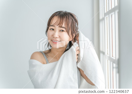 An Asian woman who towel-dries her hair after taking a bath and shampooing in the morning An Asian woman who towel-dries her hair after taking a bath and shampooing in the morning 122340637