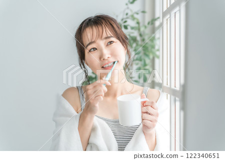 Image of a woman brushing her teeth and taking care of her oral health Image of a woman brushing her teeth and taking care of her oral health 122340651