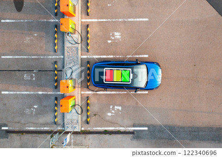 An electric car parked at a public charging station with a power indicator displayed on its roof An electric car parked at a public charging station with a power indicator displayed on its roof 122340696