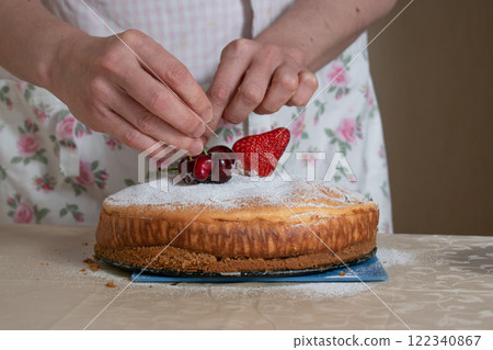 women's hands decorate the cake with berries women's hands decorate the cake with berries 122340867