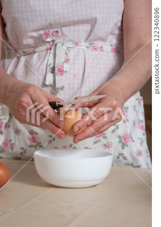 women's hands break a chicken egg 122340896