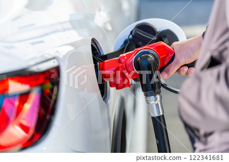 A man who refuels at a gas station A man who refuels at a gas station 122341681
