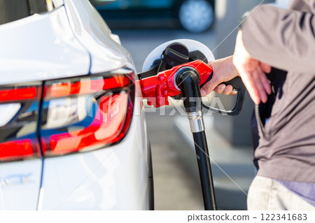 一個在加油站加油的人 122341683