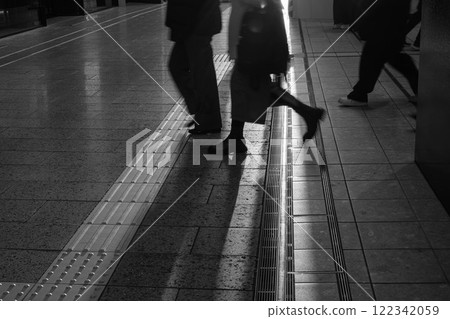 夕陽的餘暉照亮了城市裡行走的人們，勾勒出剪影。 122342059