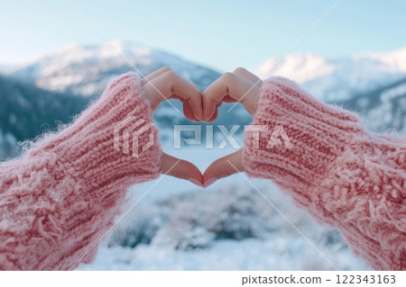 Woman making heart shape with hands in winter landscape 122343163