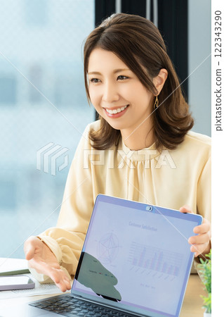 使用電腦並帶著微笑交談的女性/女商人 122343290