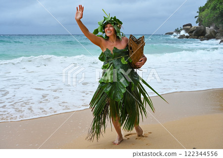 A Robinson Crusoe woman dressed in palm branches on the seashore 122344556