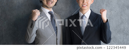 Businessmen celebrating success with fist pumps, boss and subordinate, looking at camera, no faces 122345449